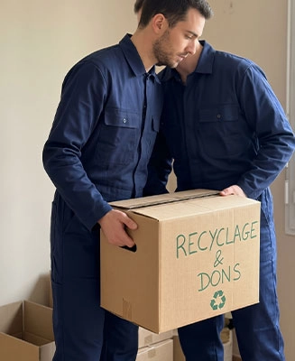 Professionnel de Débarras Responsable chargeant un carton étiqueté 'Recyclage & Dons' vert.