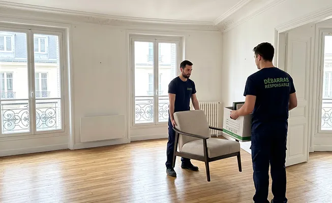 Deux travailleurs de Débarras Responsable chargeant du mobilier d'un immeuble d'habitation moderne.